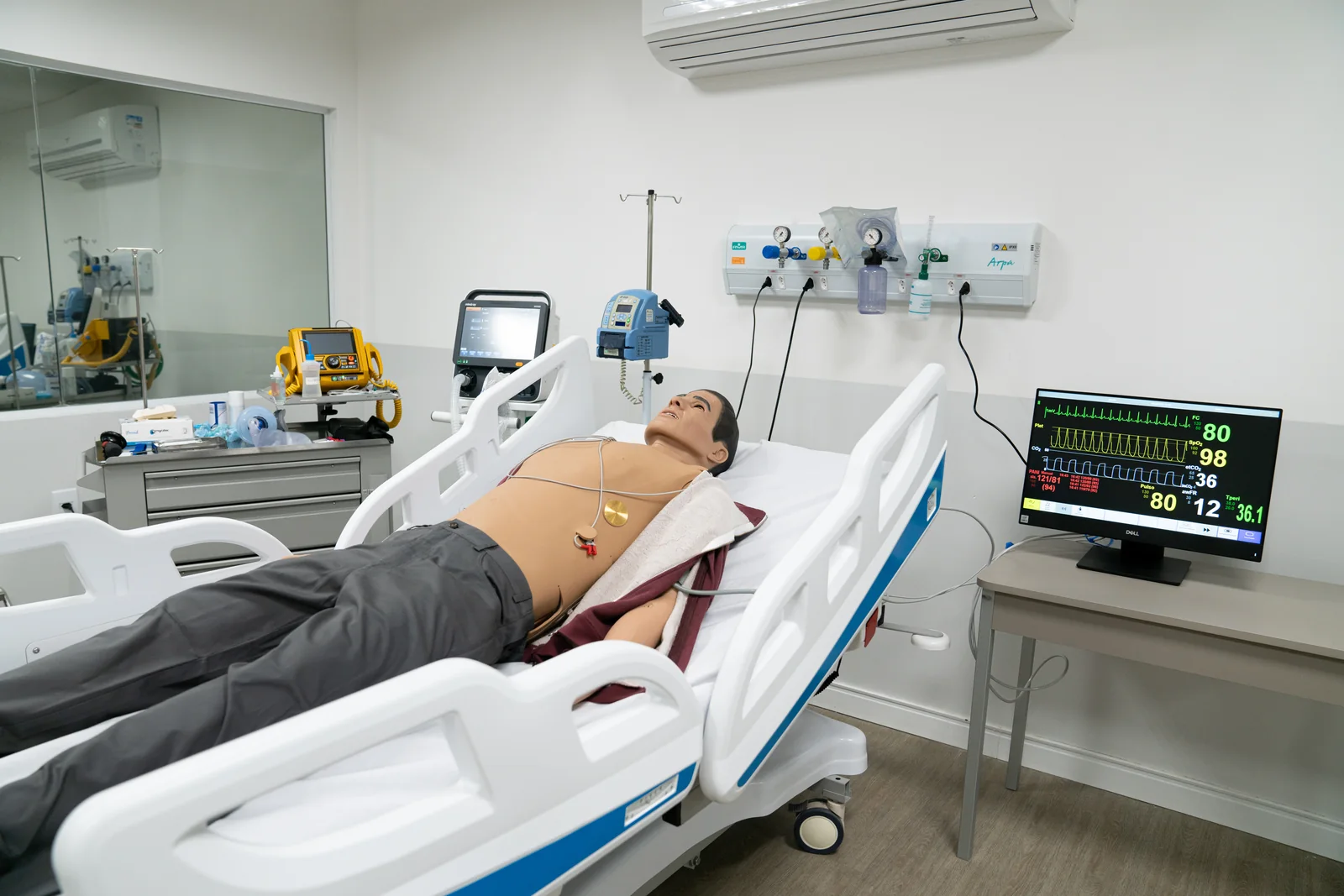 Leito equipado com simulador adulto e monitor hospitalar